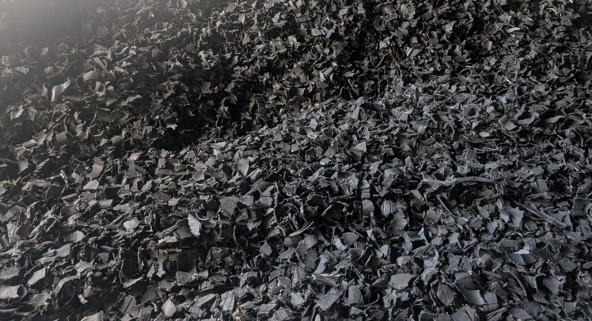 A large stockpile of high-quality bulk recycled tire shreds ready for industrial shipping at Recyclers of America
